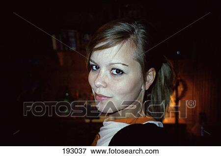 Young woman looking over her shoulder View Large Photo Image Stock Photo - Young woman looking over her shoulder. Fotosearch