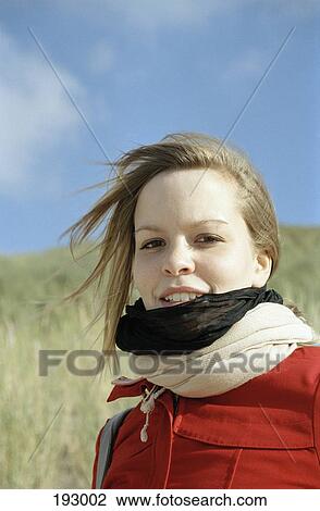 Young woman standing in field View Large Photo Image Stock Image - Young woman standing in field. Fotosearch
