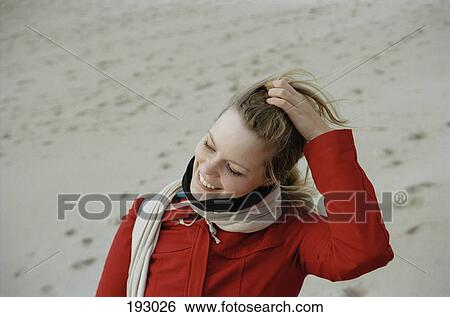 Stock Photograph - Young woman with hand in hair. Fotosearch