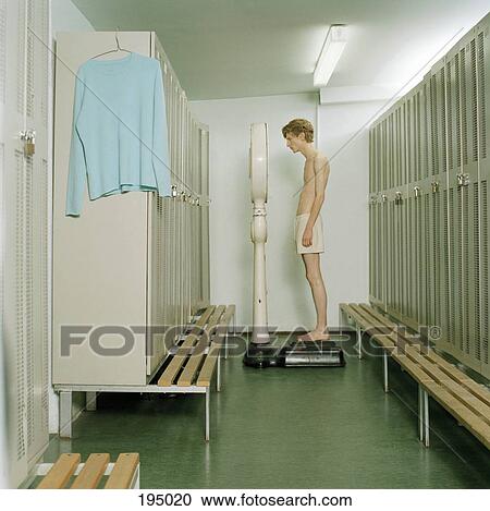A young man standing on a scale in a locker room View Large Photo Image Stock Image - A young man standing on a scale in a locker room. Fotosearch