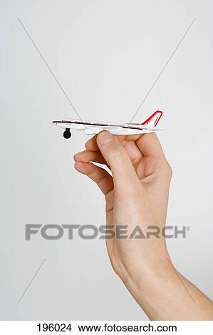 A hand holding a toy airplane View Large Photo Image Picture - A hand holding a toy airplane. Fotosearch