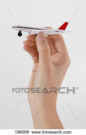 A hand holding a toy airplane View Large Photo Image Stock Photo - A hand holding a toy airplane. Fotosearch
