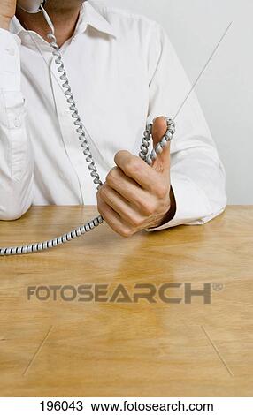 Stock Image - A man holding a telephone cord. Fotosearch