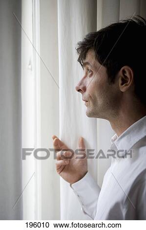 A man looking out a window View Large Photo Image Stock Image - A man looking out a window. Fotosearch