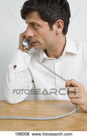 A man on a telephone looking to the side View Large Photo Image Stock Photo - A man on a telephone looking to the side. Fotosearch
