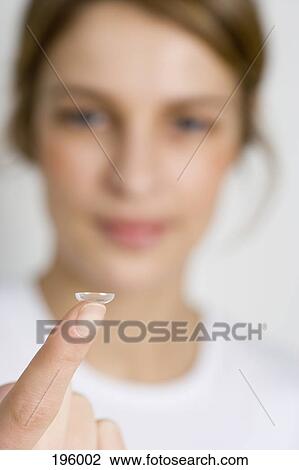 A woman holding a contact lens on her finger View Large Photo Image Stock Image - A woman holding a contact lens on her finger. Fotosearch