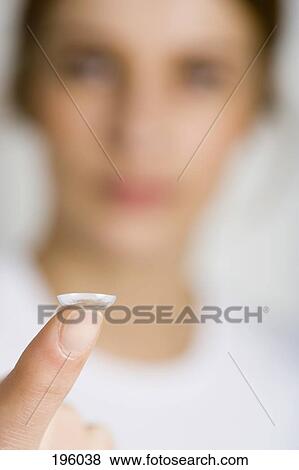 A woman holding a contact lens View Large Photo Image Stock Photo - A woman holding a contact lens. Fotosearch