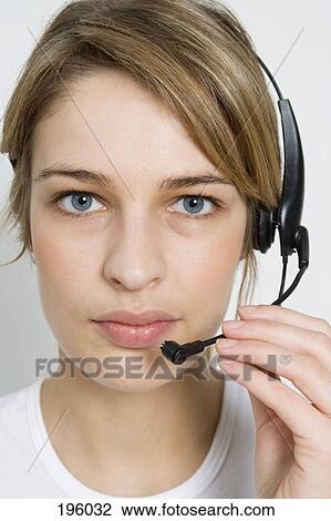 A woman holding the microphone on a headset View Large Photo Image Stock Image - A woman holding the microphone on a headset. Fotosearch