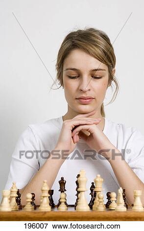 A woman looking at a chess board View Large Photo Image Stock Photo - A woman looking at a chess board. Fotosearch