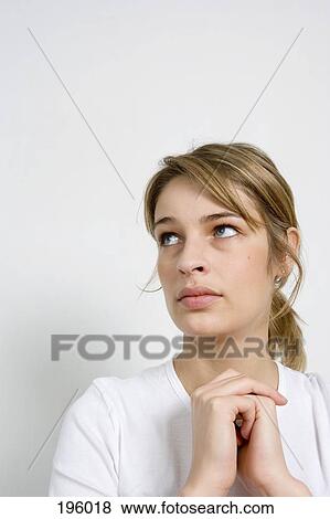 A woman with hands clasped, thinking View Large Photo Image Stock Photo - A woman with hands clasped, thinking. Fotosearch