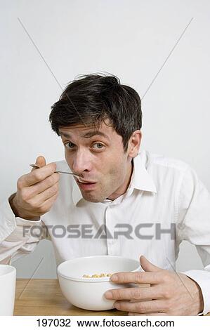 A man eating a bowl of cereal View Large Photo Image Stock Image - A man eating a bowl of cereal. Fotosearch