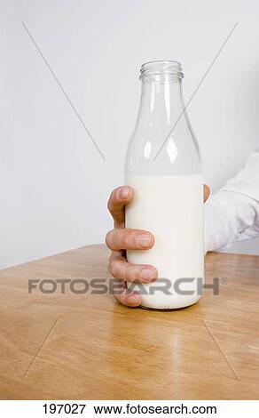 A woman holding a bottle of milk View Large Photo Image Stock Photo - A woman holding a bottle of milk. Fotosearch