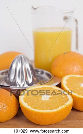 Stock Photo - Oranges with a pitcher of orange juice on a table. Fotosearch