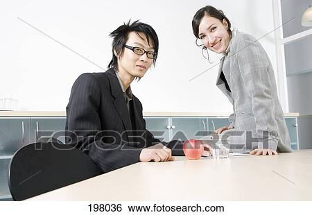 A businessman and businesswoman in a conference room View Large Photo Image Stock Photograph - A businessman and businesswoman in a conference room. Fotosearch