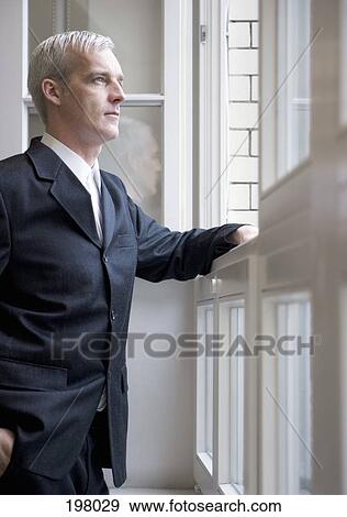 Stock Photo - A businessman looking out of a window. Fotosearch