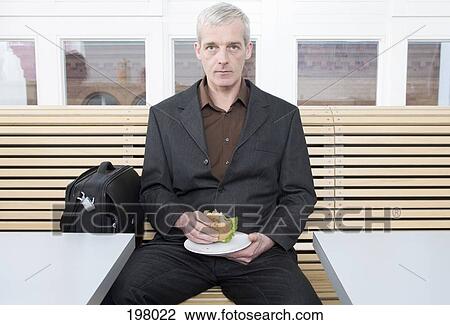 Stock Image - A businessman taking a lunch break. Fotosearch