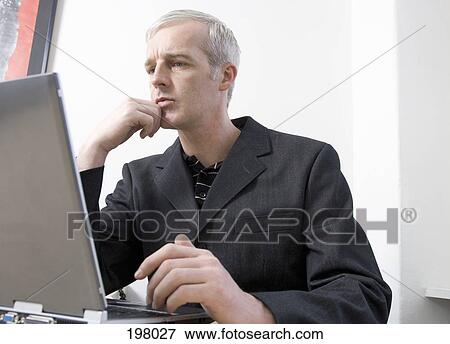 Stock Photo - A businessman working on a laptop. Fotosearch