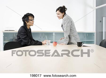 A man and a woman having a discussion in a conference room View Large Photo Image Stock Photo - A man and a woman having a discussion in a conference room. Fotosearch