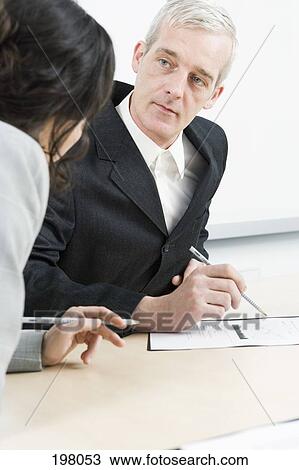 Stock Image - A man and woman in a business meeting. Fotosearch