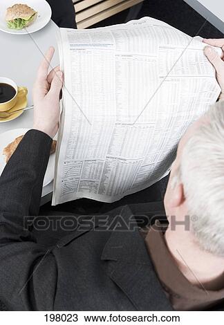 A man reading a newspaper while having breakfast View Large Photo Image Stock Image - A man reading a newspaper while having breakfast. Fotosearch