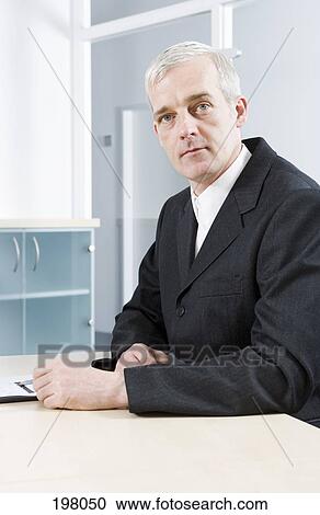 A mature businessman sitting in a conference room View Large Photo Image Stock Image - A mature businessman sitting in a conference room. Fotosearch