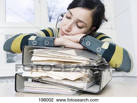 A woman sleeping on a stack of binders in an office View Large Photo Image Stock Image - A woman sleeping on a stack of binders in an office. Fotosearch