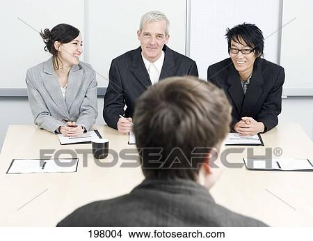 Three people interviewing a candidate in an office View Large Photo Image Picture - Three people interviewing a candidate in an office. Fotosearch