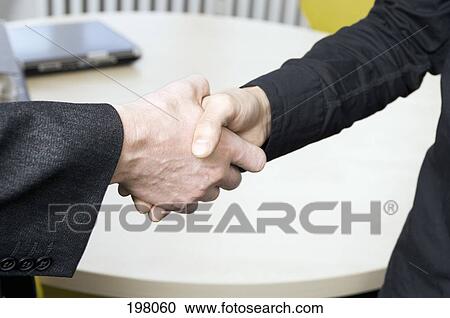 Two people shaking hands in a conference room View Large Photo Image Stock Image - Two people shaking hands in a conference room. Fotosearch