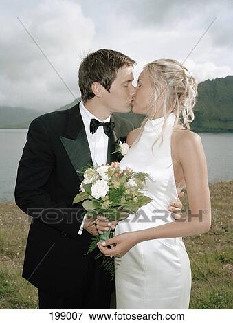A bride and groom kissing View Large Photo Image Stock Photo - A bride and groom kissing. Fotosearch