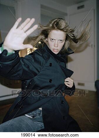 Picture - A woman making a funny karate move. Fotosearch