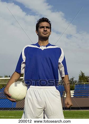 Stock Image - A soccer player holding a soccer ball. Fotosearch