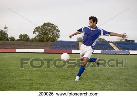 A soccer player kicking a soccer ball View Large Photo Image Stock Photograph - A soccer player kicking a soccer ball. Fotosearch