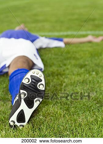 A soccer player lying on the ground View Large Photo Image Stock Image - A soccer player lying on the ground. Fotosearch