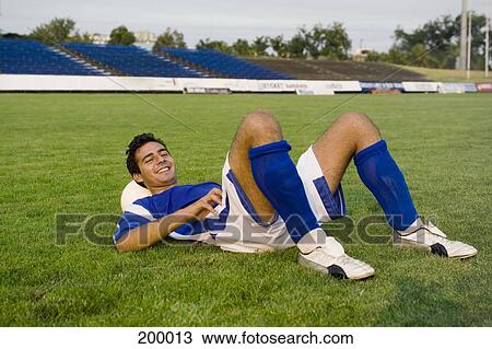 A soccer player resting on a soccer ball View Large Photo Image Stock Image - A soccer player resting on a soccer ball. Fotosearch