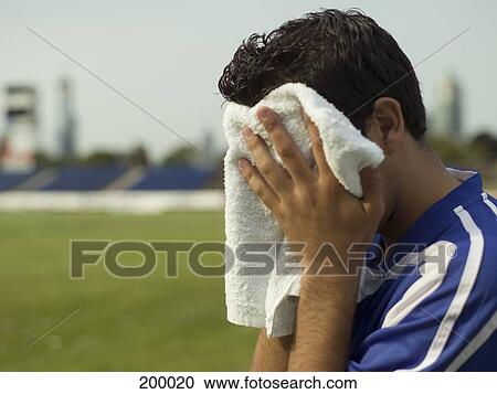 A soccer player wiping his face with a towel View Large Photo Image Stock Image - A soccer player wiping his face with a towel. Fotosearch