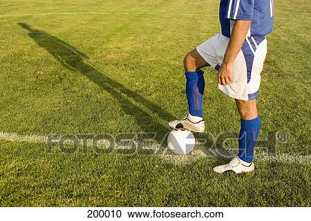 Stock Image - A soccer player with his foot on the ball. Fotosearch