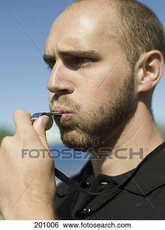 Stock Photograph - A referee blowing a whistle. Fotosearch