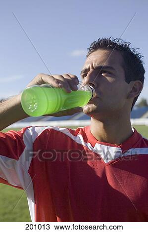 Stock Image - A soccer player drinking a sports drink. Fotosearch