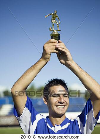 A soccer player holding up a trophy View Large Photo Image Stock Photo - A soccer player holding up a trophy. Fotosearch