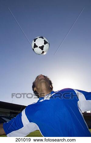 A soccer player looking up at a ball in the sky View Large Photo Image Stock Photo - A soccer player looking up at a ball in the sky. Fotosearch