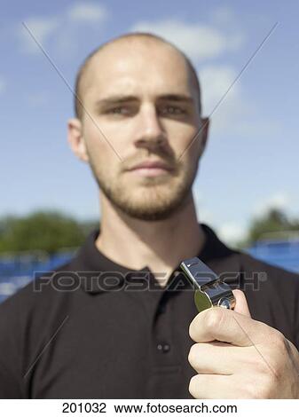 Stock Image - A sports referee holding a whistle. Fotosearch
