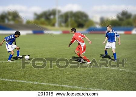 Three people playing soccer View Large Photo Image Stock Photography - Three people playing soccer. Fotosearch