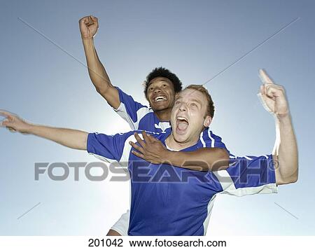 Stock Image - Two soccer players celebrating. Fotosearch