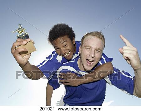 Two soccer players celebrating with a trophy View Large Photo Image Stock Image - Two soccer players celebrating with a trophy. Fotosearch