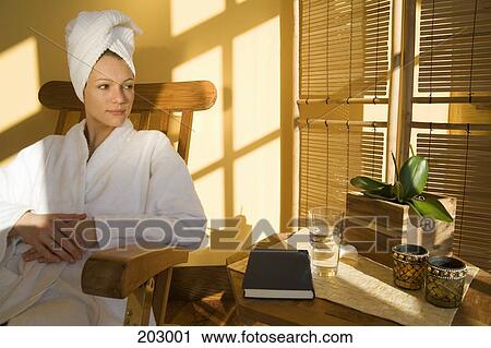 Woman sitting in chair wearing bathrobe View Large Photo Image Stock Image - Woman sitting in chair wearing bathrobe. Fotosearch