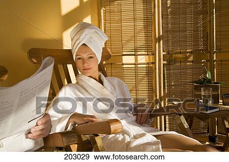 Young woman in bathrobe reclining in wooden chair View Large Photo Image Stock Photo - Young woman in bathrobe reclining in wooden chair. Fotosearch