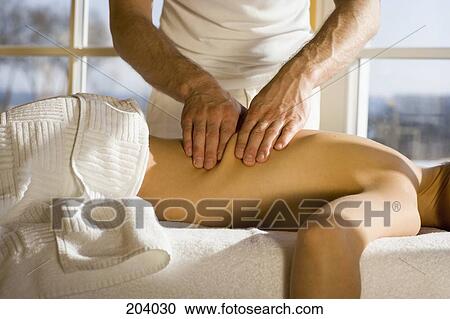 Young woman lying on front receiving back massage View Large Photo Image Stock Image - Young woman lying on front receiving back massage. Fotosearch