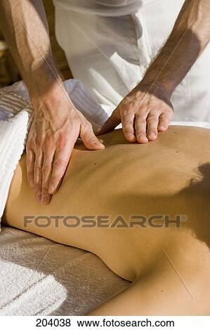 Young woman lying on front receiving back massage View Large Photo Image Stock Photo - Young woman lying on front receiving back massage. Fotosearch