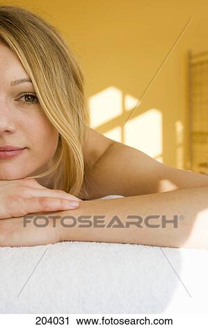 Stock Image - Young woman lying on massage table. Fotosearch