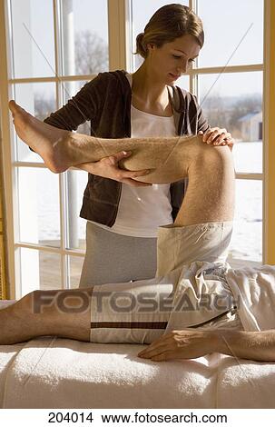 Picture - Young woman massaging man massage. Fotosearch